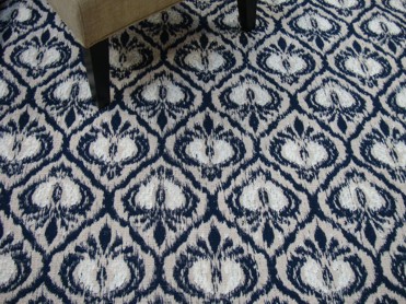 Cezanne, Color: Navy 7/5250 styled with chair as prop. Cezanne is a flatweave with a modern, distressed damask design. This colorway has tones of navy, beige and white.