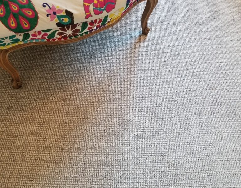 Eco Tweed 8155A shown with chair covered in colorful fabric. Eco Tweed is tufted as a textured loop pile two colors of heathered yarns to create a grid like pattern.