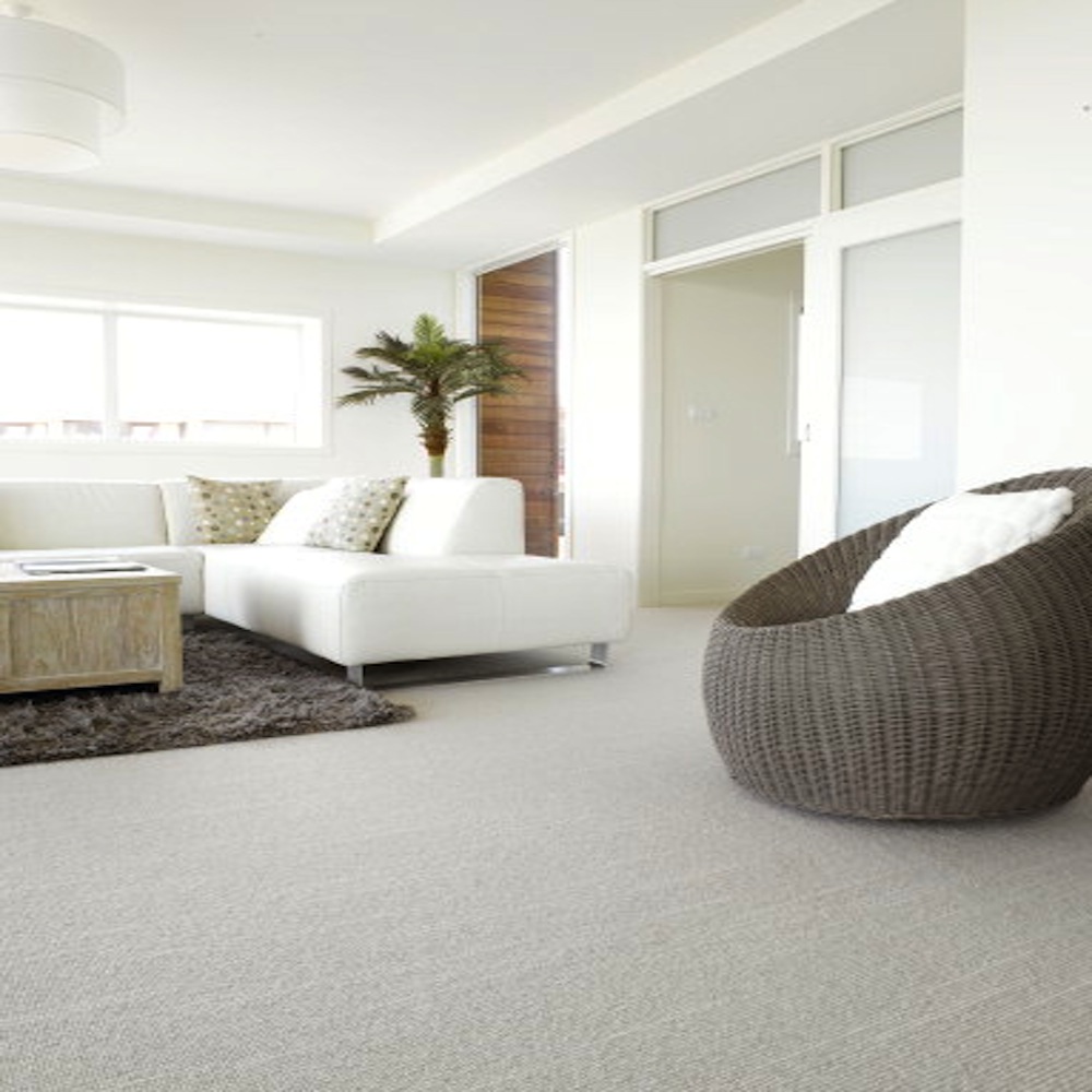 Tussore, Color: Sumac 7/3020 installed in living room. Various living room furnishings are seen in the image. Tussore Sumac is a textured loop pile fabricated with felted yarns (lt grey). Random linear striations appear across the broadloom.