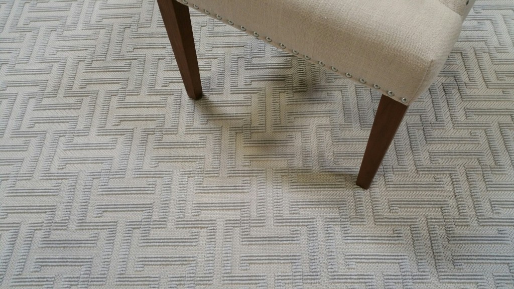 Xenia, Color: Lt Gold 28/8002 shown with chair used as prop. Xenia is comprised of tencel. Image shows a close up of Xenia's high/low graphic pattern in a loop construction.