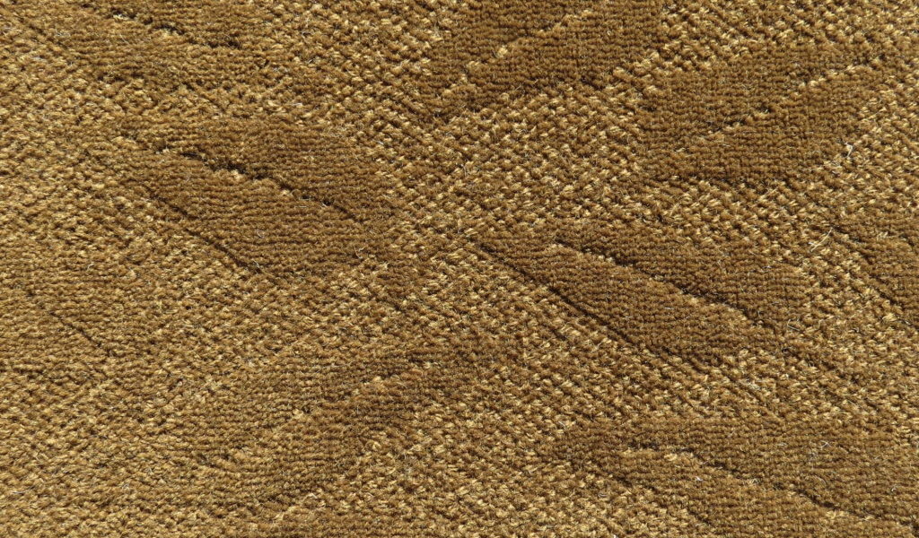 Bellbridge Falling Leaves Oak /469625 color swatch. Falling Leaves is constructed as a solid color tip shear with leaf design scattered randomly across the carpet. Color shown has a rich bronze tone.