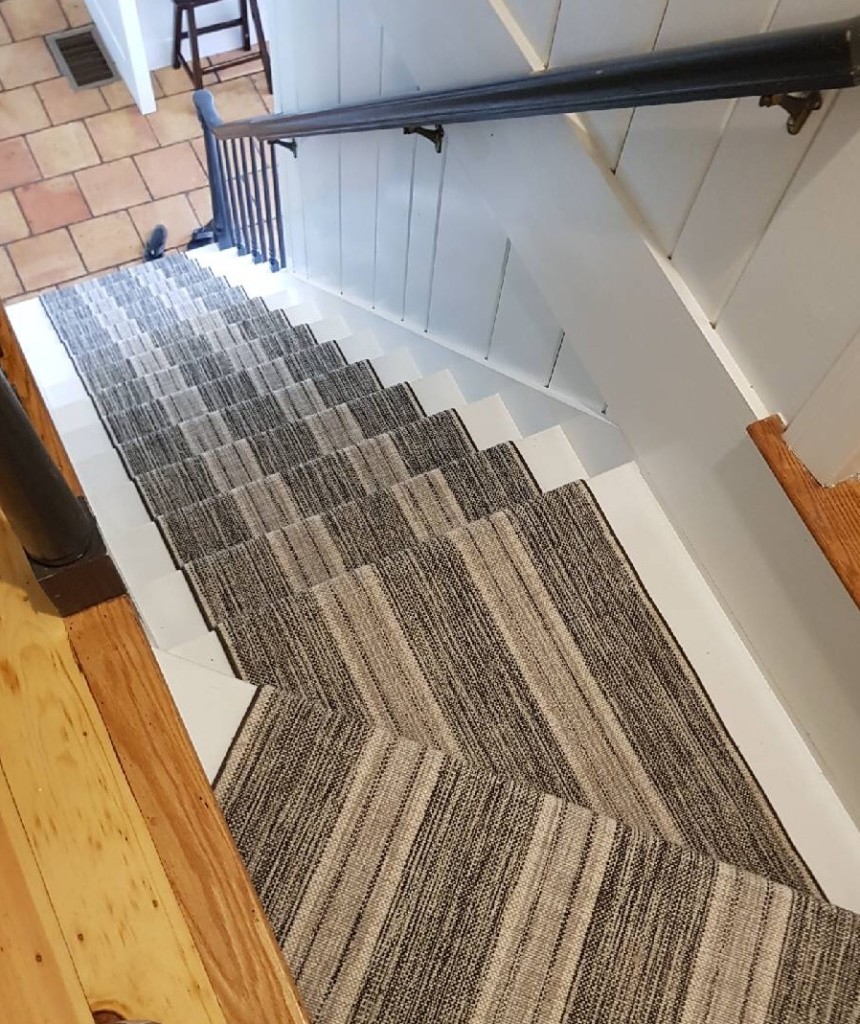 Linen Stripe, Color Charcoal Silver 31/5703 installed on stairwell by Cape Cod Custom Floors, located in Hyannis, MA. Linen Stripe has stripes that run the length of the carpet/stairwell. This colorway has hues of charcoal, silver and white.