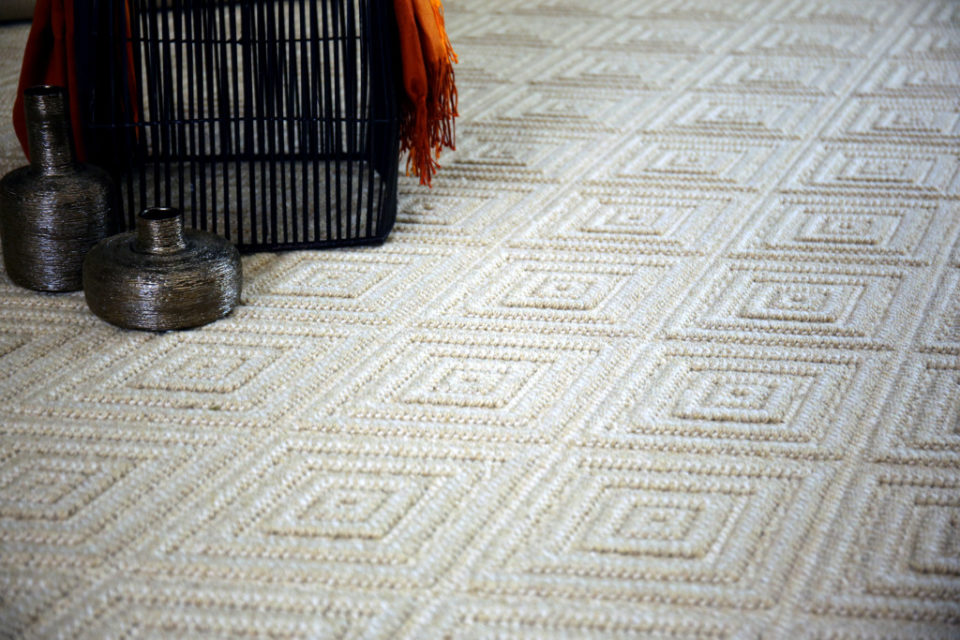 nca, Color: Lt Camel 30/5202 Inca, Color: Lt Camel 30/5202 shown with basket and other decorative items. Inca is a wilton loop pile woven with 2 colors of yarn (lt camel/creme) to create a diamond within a diamond pattern.