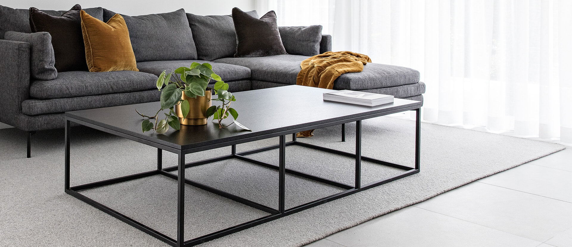 Levante finished rug shown in living room with furnishings. Levante is a textured loop pile fabricated with heathered yarns.