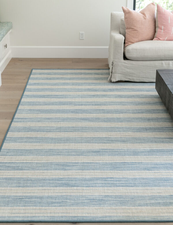 Linen Stripe serged rug, Color: Marina Blue/Sand 350F/5703F in room setting with furnishings. Linen Stripe serged rug, Color: Marina Blue/Sand 350F/5703F in room setting with furnishings. Linen Stripe has stripes that go along the width of the carpet.