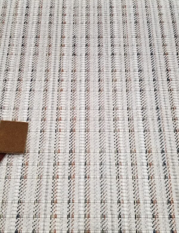 Traverse, Color: Copper/Navy 49/5778 Traverse, Color: Copper/Navy 49/5778 shown with yarn poms and carpet swatches, used as props.